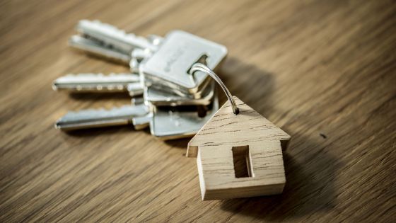 Clés avec un porte-clés en forme de maison en bois posées sur une table