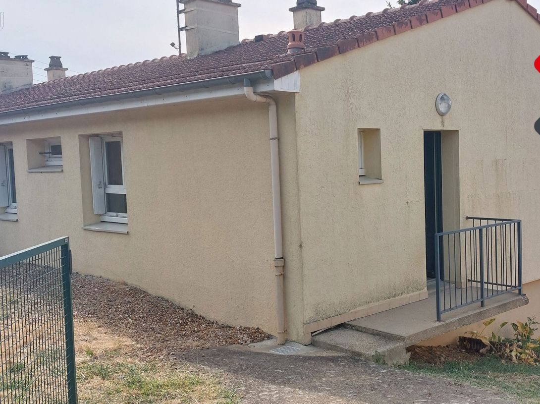 Maison de plain-pied avec jardin et garage.