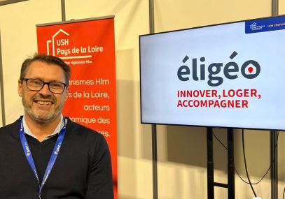 Cyril RAFFIER devant un écran sur lequel figure le logo d'éligéo en grand.