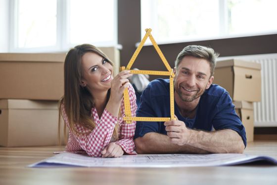 Un couple étudie les plans de sa maison au milieu des cartons